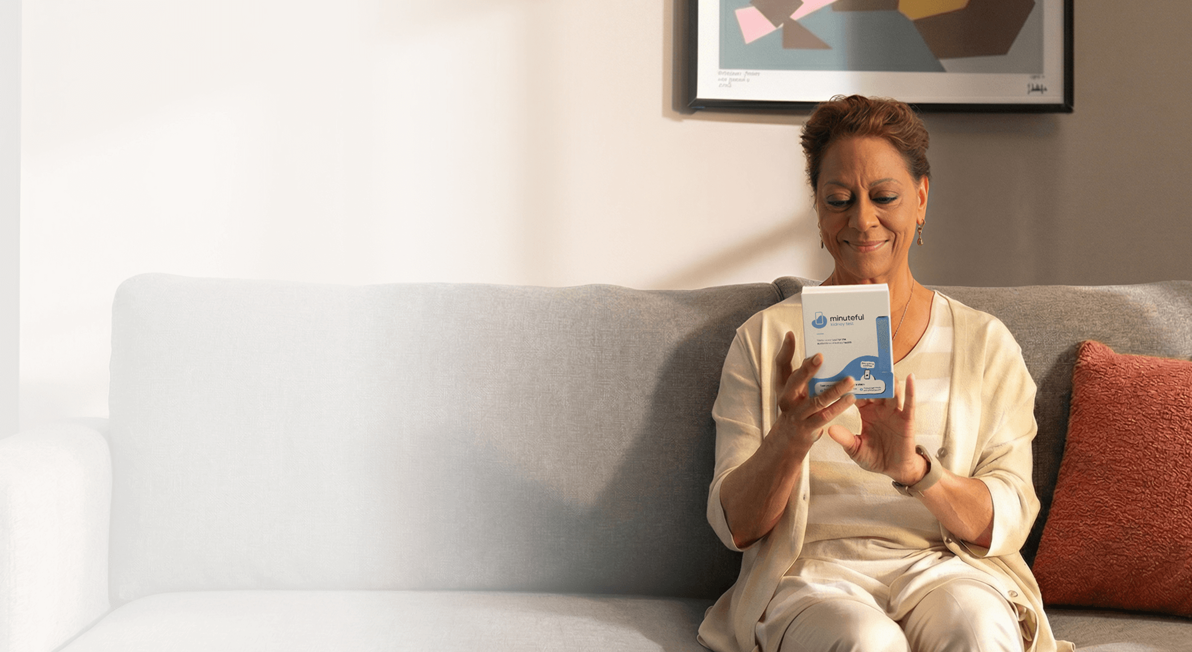 Woman smiling while holding Minuteful Kidney test